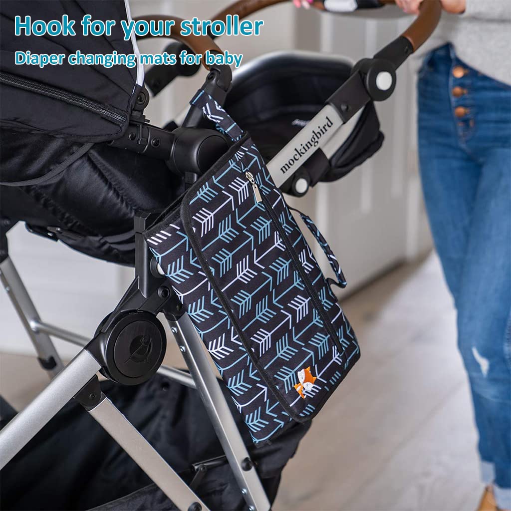 Baby lying on a foldable padded diaper changing mat with built-in wipes and organizer pouch, perfect for travel and newborn care.