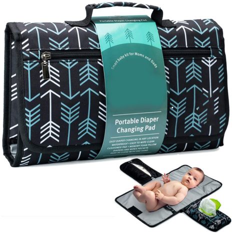 Baby lying on a foldable padded diaper changing mat with built-in wipes and organizer pouch, perfect for travel and newborn care.
